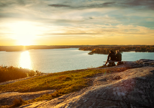 par på en bänk blickar ut på solnedgång över sjö